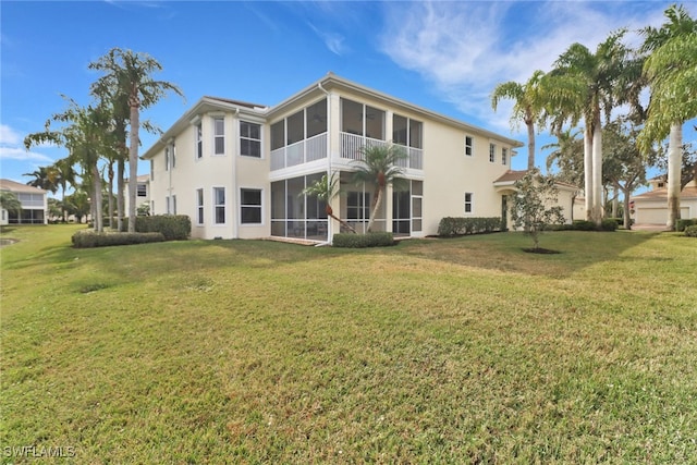 rear view of house with a sunroom and a lawn