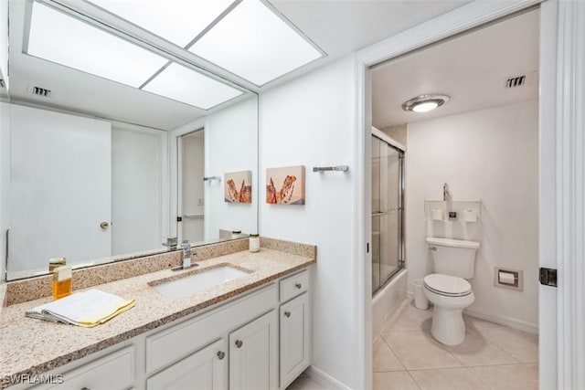 full bathroom featuring tile patterned floors, vanity, enclosed tub / shower combo, and toilet