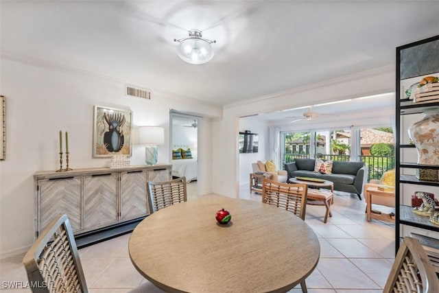 dining space featuring ceiling fan, light tile patterned flooring, and crown molding