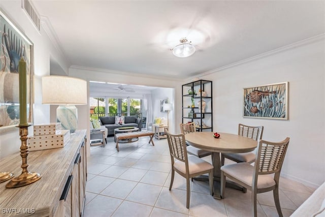 tiled dining area with ceiling fan and crown molding