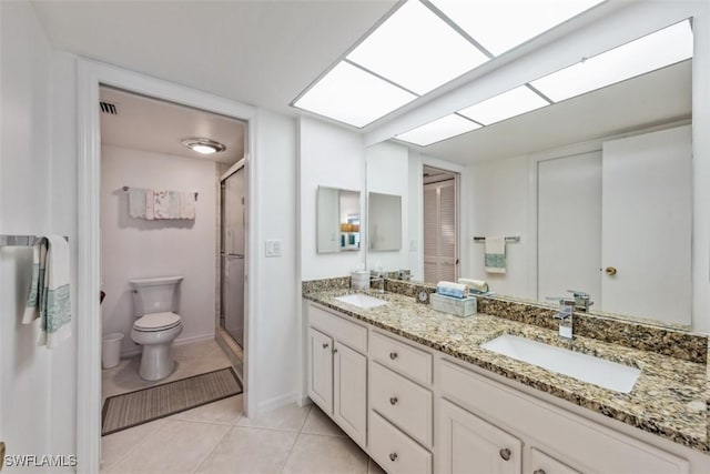 bathroom featuring tile patterned flooring, vanity, toilet, and a shower with door