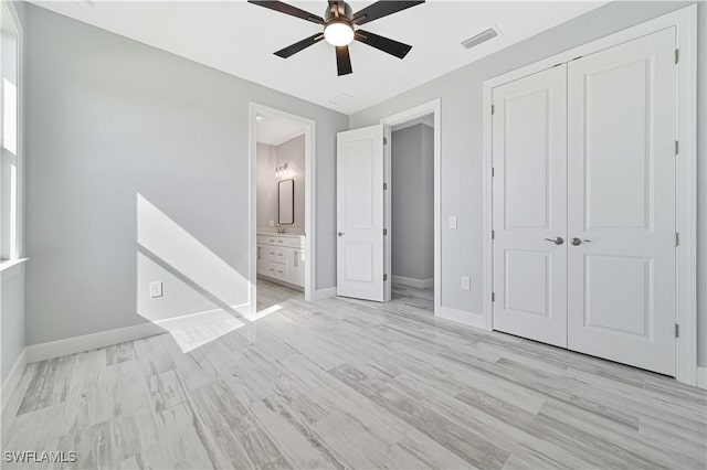 unfurnished bedroom with ceiling fan, a closet, and ensuite bathroom