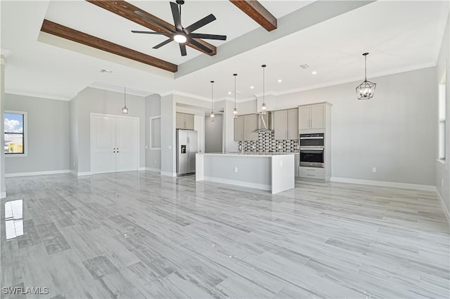 unfurnished living room with ceiling fan with notable chandelier, beam ceiling, and a tray ceiling