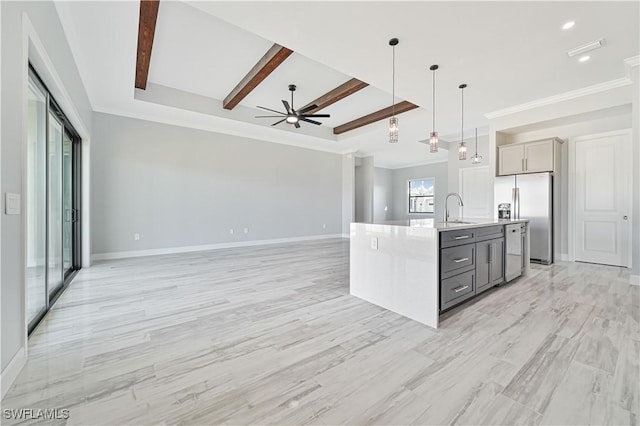 kitchen featuring ceiling fan, hanging light fixtures, stainless steel refrigerator with ice dispenser, gray cabinets, and a kitchen island with sink