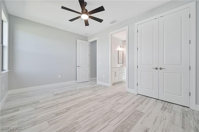 unfurnished bedroom featuring a closet, ceiling fan, light hardwood / wood-style floors, and ensuite bathroom