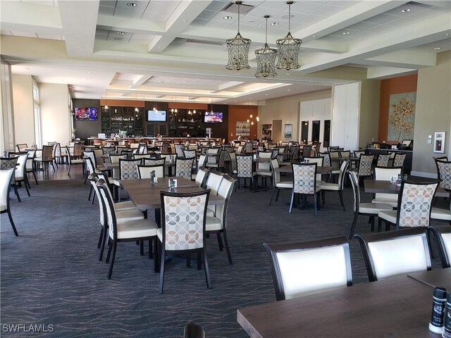 carpeted dining room with beamed ceiling