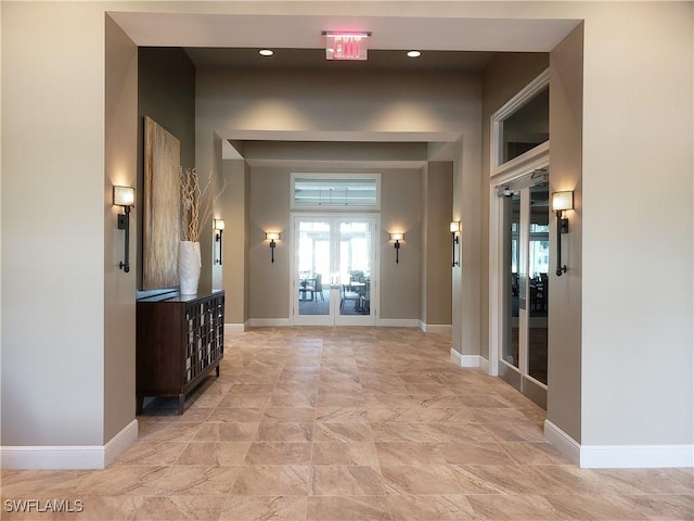 hall featuring baseboards and french doors