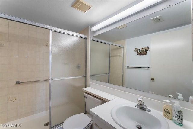 bathroom featuring toilet, a shower with door, and vanity