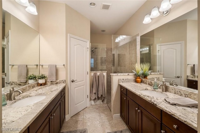 bathroom with tiled shower and vanity