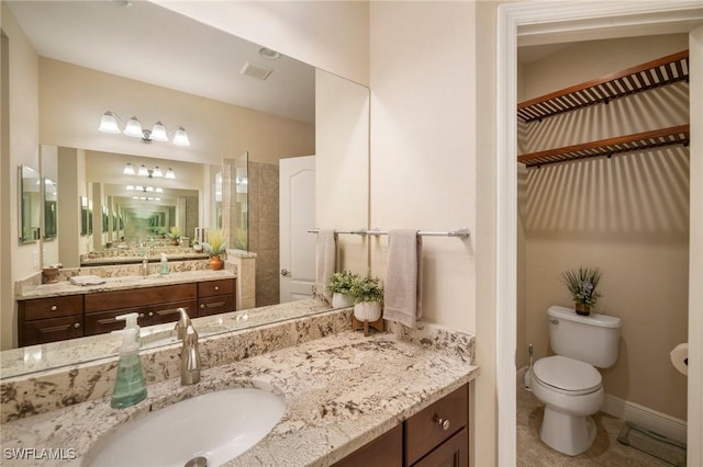 bathroom featuring toilet, walk in shower, and vanity