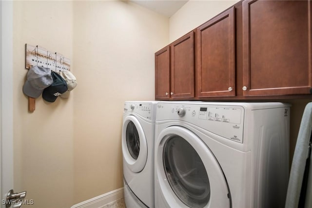 washroom featuring cabinets and washing machine and clothes dryer