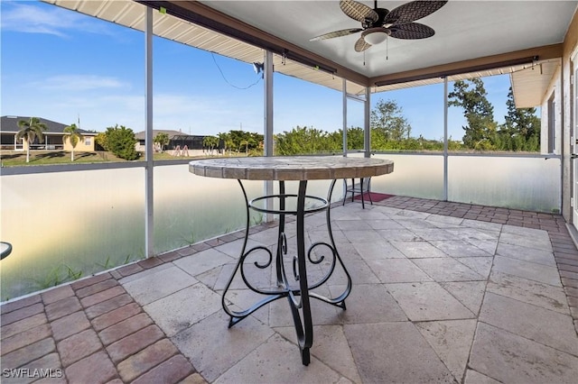 unfurnished sunroom with ceiling fan