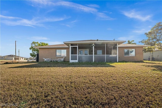 21 NE 19th Ter, Cape Coral, FL 33909 - rear view of house with a sunroom, stucco siding, fence, and a lawn