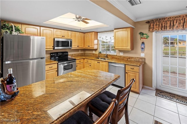 kitchen featuring stainless steel appliances, a healthy amount of sunlight, sink, and light tile patterned floors