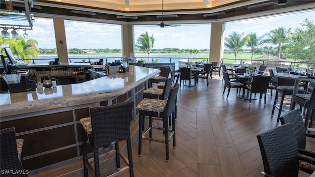 kitchen featuring dark parquet flooring, a water view, and a healthy amount of sunlight