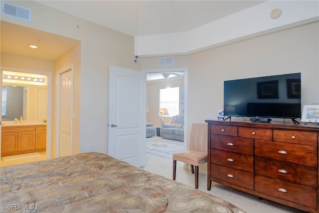 carpeted bedroom featuring connected bathroom and sink