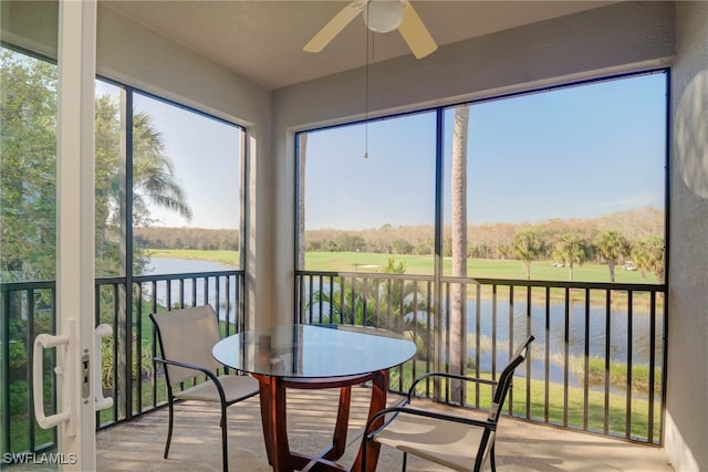 sunroom with ceiling fan, plenty of natural light, and a water view