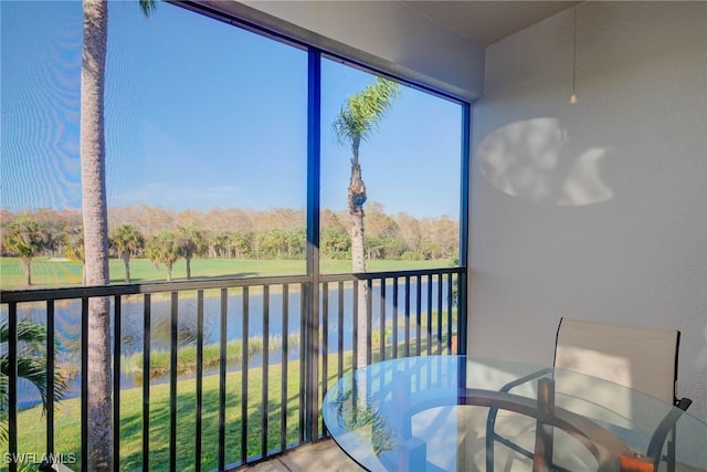 sunroom / solarium featuring a water view