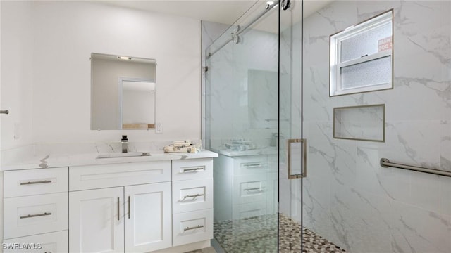 bathroom featuring a shower with door and vanity