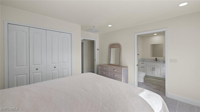 bedroom featuring ensuite bathroom, sink, and a closet