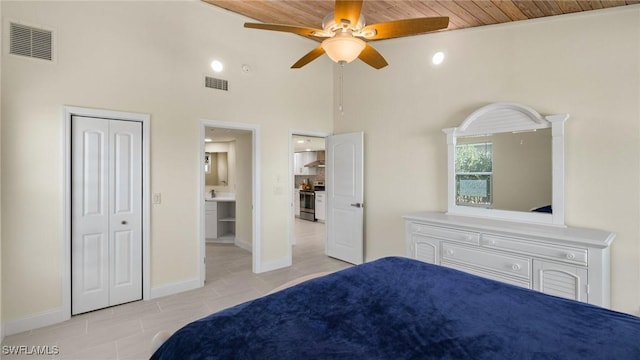 bedroom with ceiling fan, a closet, wood ceiling, and a high ceiling