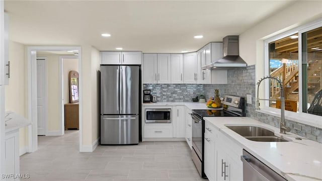 kitchen with sink, stainless steel appliances, plenty of natural light, and wall chimney range hood