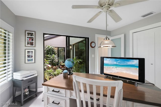 dining space with a healthy amount of sunlight, ceiling fan, and visible vents