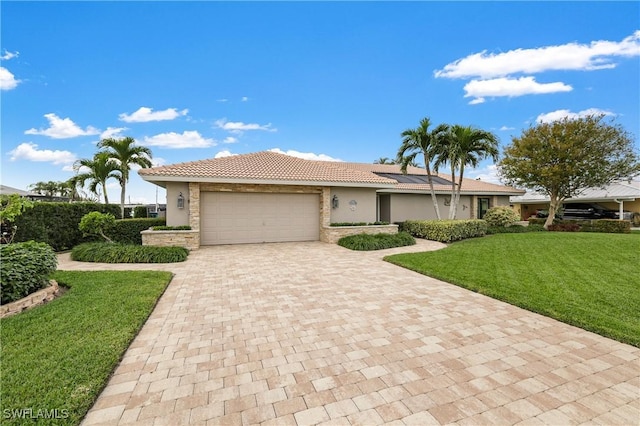 ranch-style home featuring a garage, a tile roof, decorative driveway, a front yard, and stucco siding