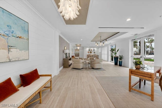 living room with french doors, light hardwood / wood-style floors, an inviting chandelier, and crown molding