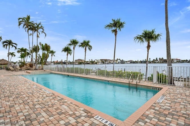 view of swimming pool featuring a patio area and a water view