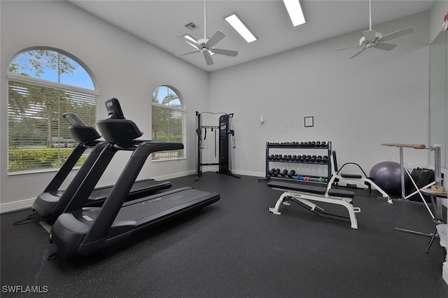 gym with ceiling fan and high vaulted ceiling