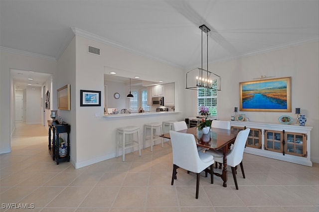 tiled dining area featuring ornamental molding and a chandelier