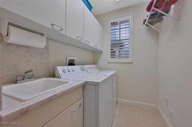 laundry area with separate washer and dryer, sink, light tile patterned floors, and cabinets