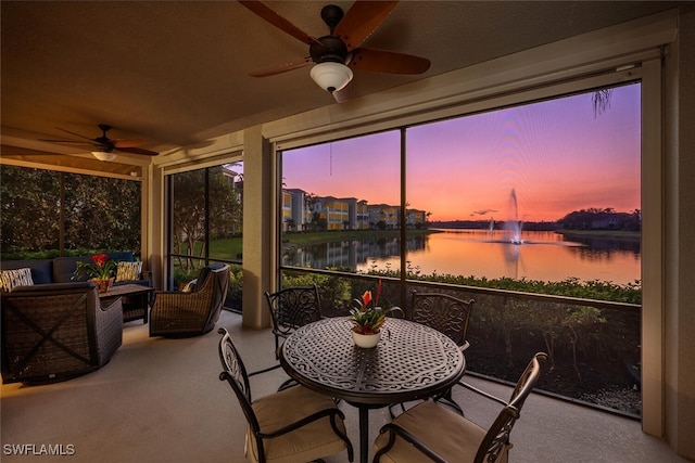 sunroom / solarium featuring a water view and ceiling fan