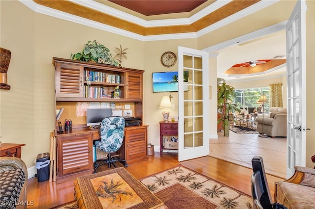 office featuring hardwood / wood-style floors, a raised ceiling, ornamental molding, and french doors