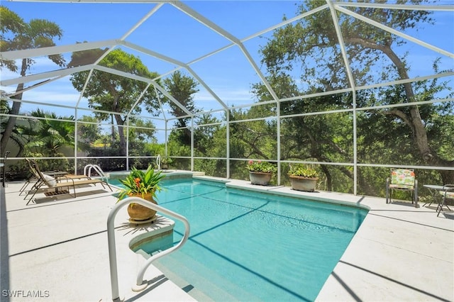 view of swimming pool featuring glass enclosure and a patio