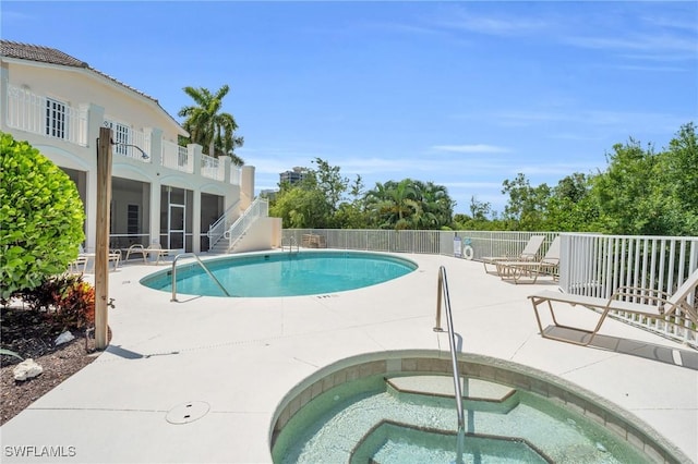 view of pool with a sunroom, a patio, and a hot tub