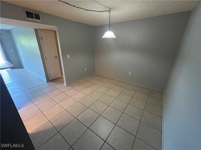 tiled spare room with a textured ceiling