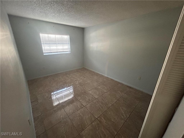 unfurnished room featuring a textured ceiling