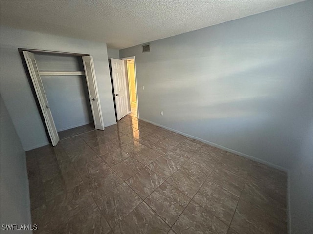 unfurnished bedroom featuring a closet and a textured ceiling