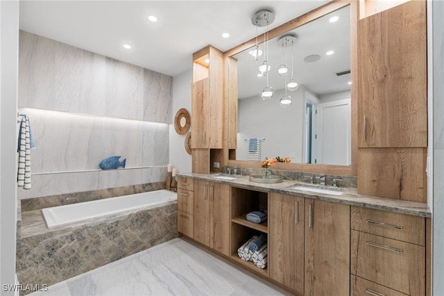 bathroom with vanity and a relaxing tiled tub