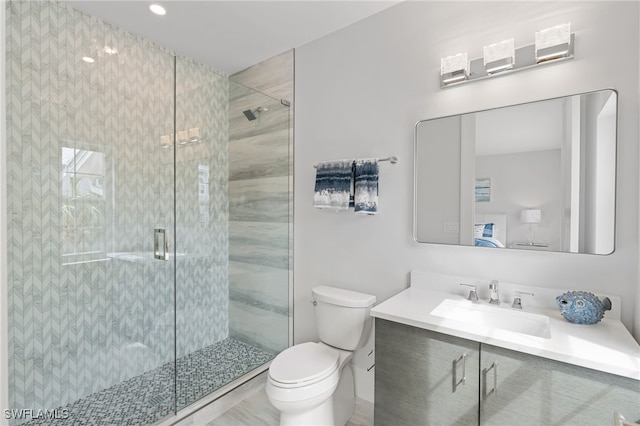 bathroom featuring toilet, an enclosed shower, and vanity