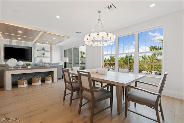 dining area featuring light hardwood / wood-style flooring and a notable chandelier