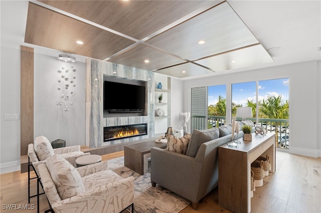 living room featuring wooden ceiling, a large fireplace, and light hardwood / wood-style floors