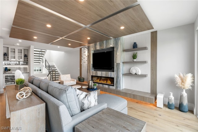 living room featuring wood ceiling, a fireplace, and light hardwood / wood-style flooring