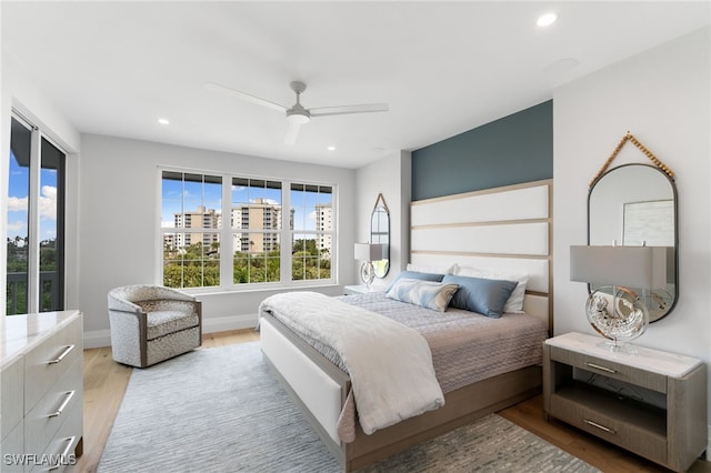 bedroom with ceiling fan and light hardwood / wood-style floors