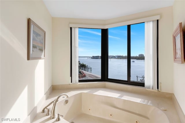 bathroom featuring a washtub and a water view