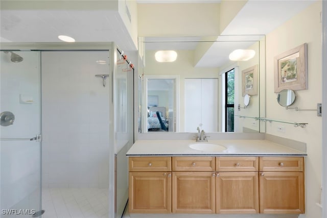 bathroom featuring a shower with door and vanity