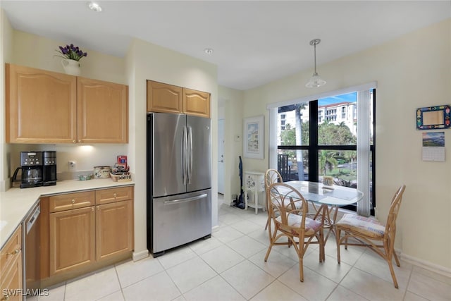 kitchen with decorative light fixtures, light brown cabinets, stainless steel appliances, and light tile patterned floors