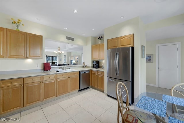 kitchen with sink, light tile patterned flooring, a notable chandelier, and appliances with stainless steel finishes